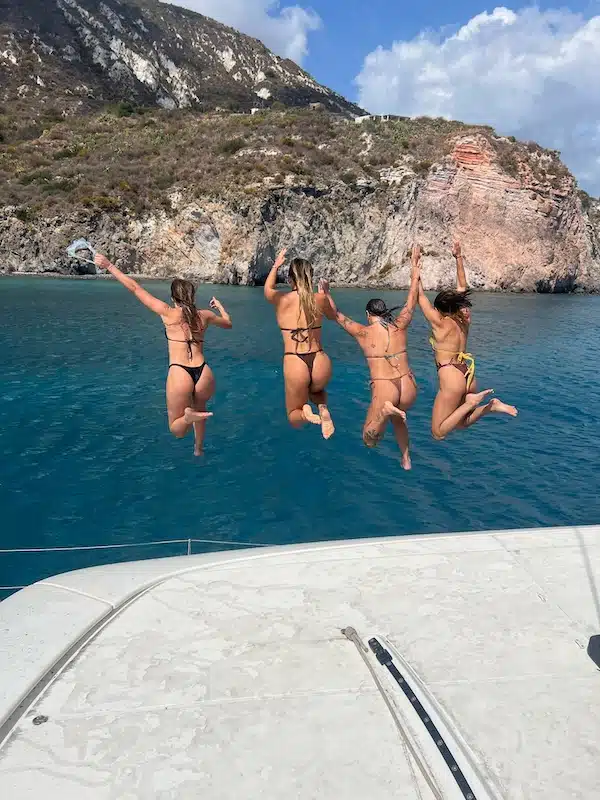 Four women jumping into sea - Lowtide Sailing