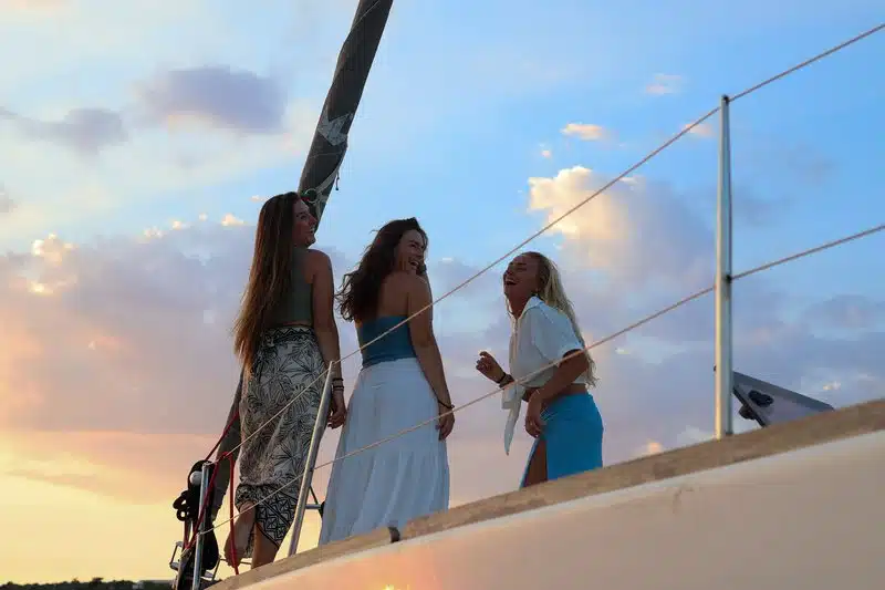 Students enjoying sunset on sailing yacht