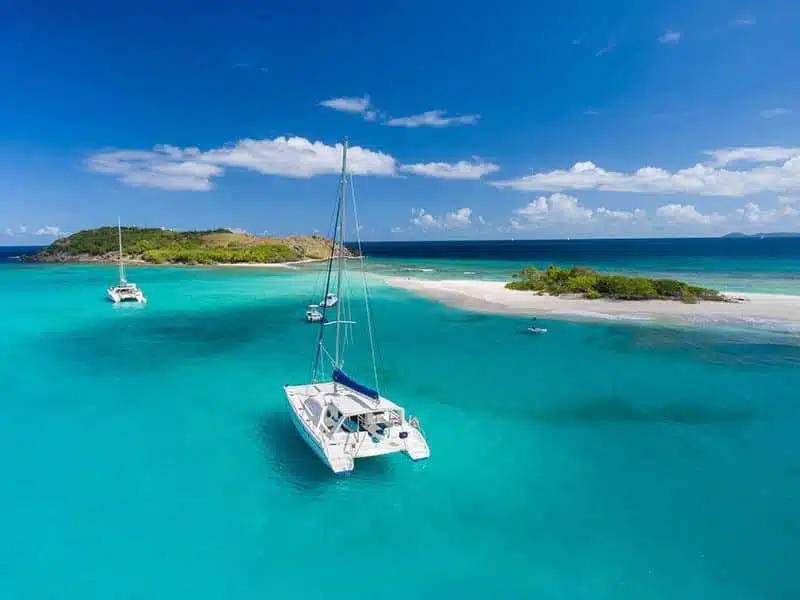 Catamarans anchored beside a white sandbar in the British Virgin Islands